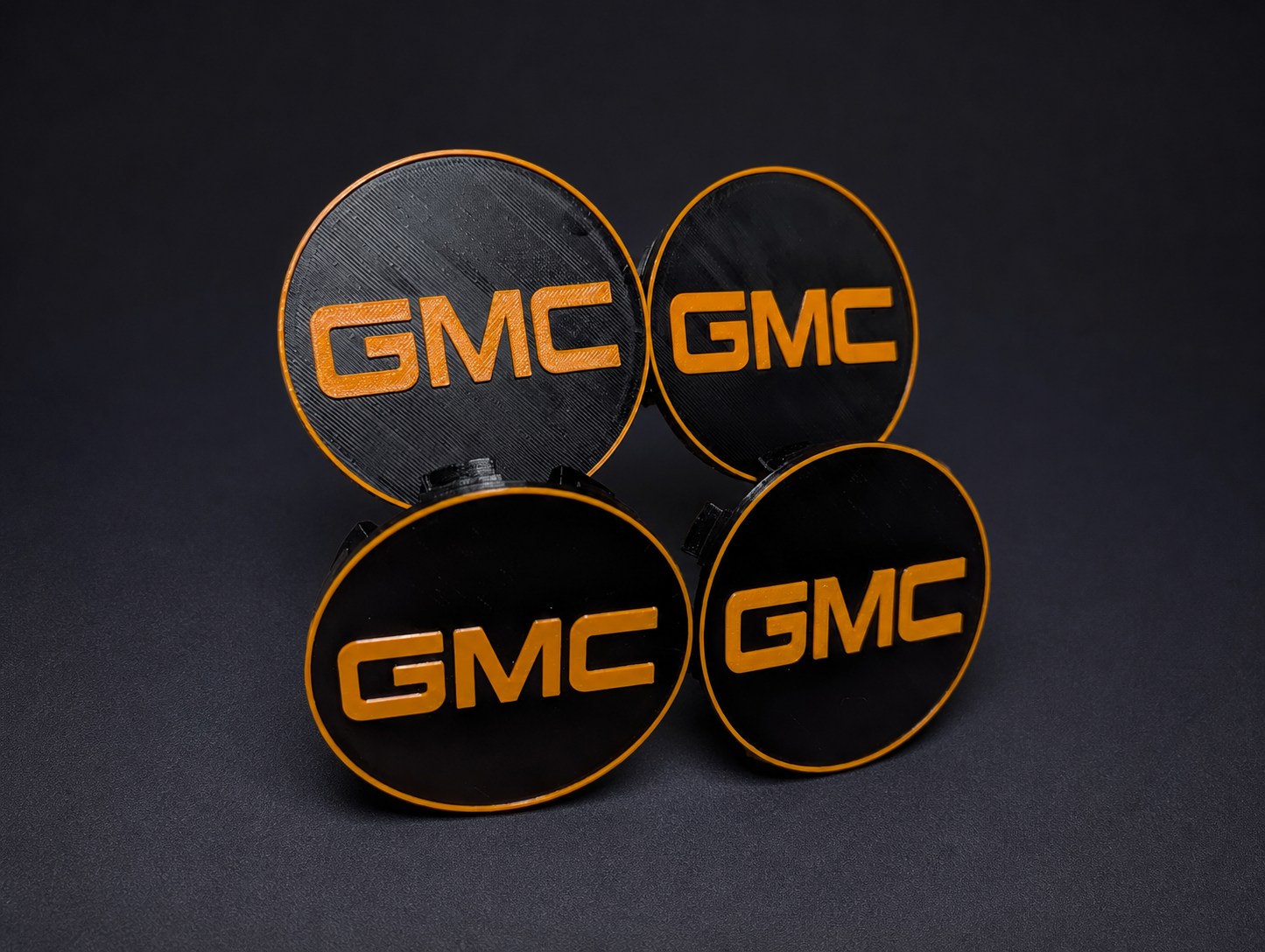 Set of four custom black and orange GMC wheel center caps