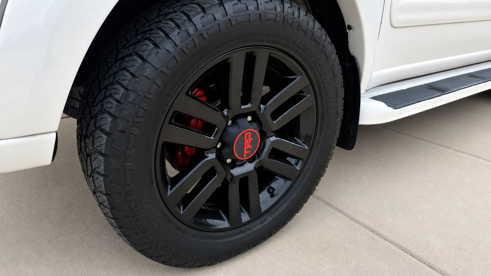 Red TRD custom wheel center cap installed on a vehicle