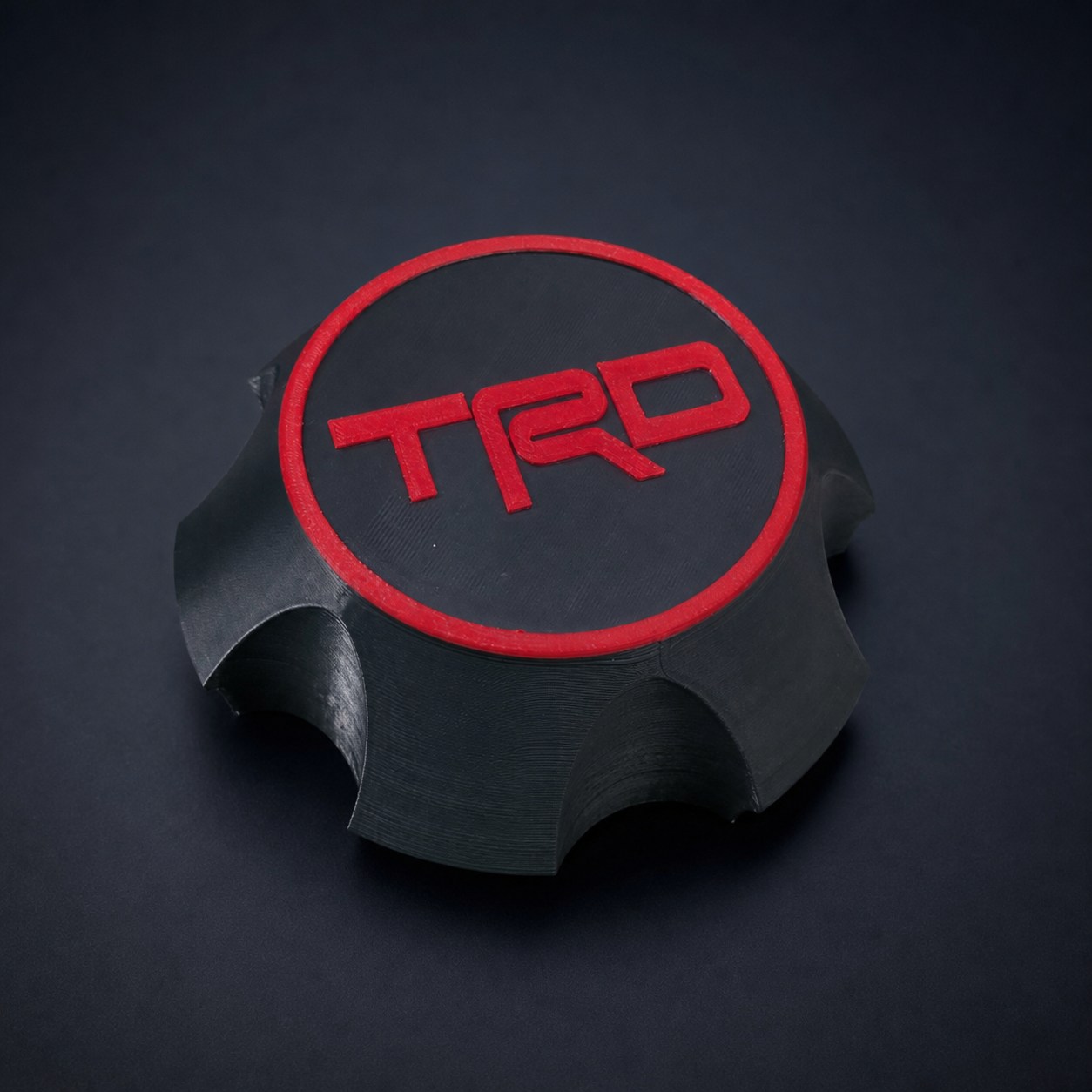 Black and red TRD-style wheel center cap for a 2005 to 2007 Toyota Sequoia